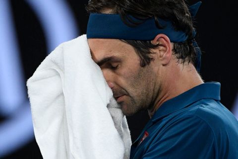 Switzerland's Roger Federer wipes the sweat from his face during his fourth round match against Greece's Stefanos Tsitsipas at the Australian Open tennis championships in Melbourne, Australia, Sunday, Jan. 20, 2019. (AP Photo/Andy Brownbill)