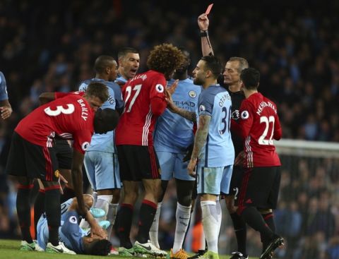 Manchester United's Marouane Fellaini, center, is sent off by given a red card during the English Premier League soccer match between Manchester City and Manchester United at the Etihad Stadium in Manchester, England,Thursday, April 27, 2017.(AP Photo/Dave Thompson)