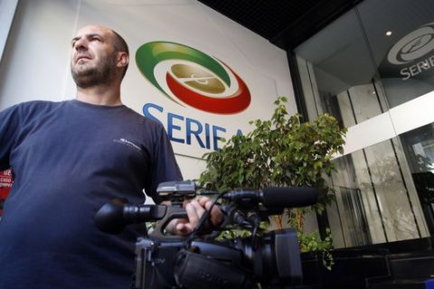 A cameraman stands in front of a Serie A logo at the 'Lega Calcio' headquarter in Milan, Italy, Friday, Aug. 19, 2011. (AP Photo/Luca Bruno)