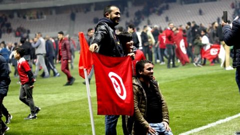 Tunisian supporters pose with their national flag on the pitch after a friendly soccer match between Tunisia and Costa Rica at the Allianz Riviera stadium in Nice, southern France, Tuesday, March 27, 2018. (AP Photo/Claude Paris)
