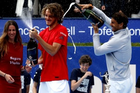 Spain's Rafael Nadal, right, pours sparkling wine on Greece's Stefanos Tsitsipas after winning the Barcelona Open Tennis Tournament final in Barcelona, Spain, Sunday, April 29, 2018. Nadal defeated Greece's Stefanos Tsitsipas 6-2, 6-1 in the final. (AP Photo/Manu Fernandez)
