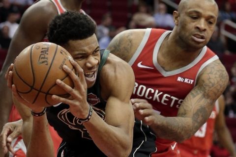 Milwaukee Bucks forward Giannis Antetokounmpo, left, protects his rebound from Houston Rockets forward PJ Tucker, right, during the first half of an NBA basketball game Wednesday, Jan. 9, 2019, in Houston. (AP Photo/Michael Wyke)
