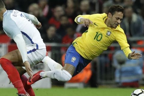 Brazil's Neymar is fouled by England's Jake Livermore during the international friendly soccer match between England and Brazil at Wembley stadium in London, Britain, Tuesday, Nov. 14, 2017. (AP Photo/Matt Dunham)