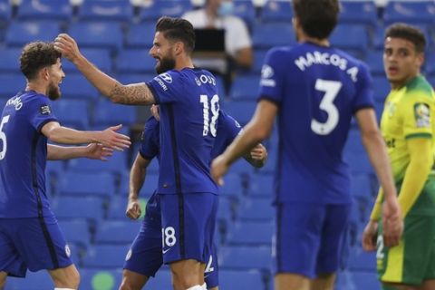 Chelsea's Olivier Giroud, centre, is congratulated by teammates after scoring his team's first goal during the English Premier League soccer match between Chelsea and Norwich City at Stamford Bridge in London, England, Tuesday, July 14, 2020. (AP Photo/Richard Heathcote,Pool)