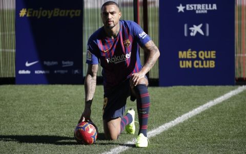 FC Barcelona new signing Kevin-Prince Boateng kneels on the pitch during his presentation at the Camp Nou stadium in Barcelona, Spain, Tuesday, Jan. 22, 2019. Barcelona surprisingly signed Kevin-Prince Boateng on loan from Italian club Sassuolo on Monday until the end of the season. The 31-year-old Boateng has appeared to be past his prime after playing for the likes of AC Milan, Borussia Dortmund, Schalke, and Tottenham. (AP Photo/Emilio Morenatti)