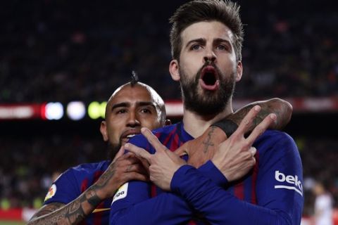 FC Barcelona's Gerard Pique, right, celebrates with his teammate Arturo Vidal after scoring his side's first goal during the Spanish La Liga soccer match between FC Barcelona and Rayo Vallecano at the Camp Nou stadium in Barcelona, Spain, Saturday, March 9, 2019. (AP Photo/Manu Fernandez)