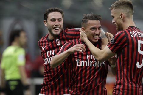 AC Milan's Ismael Bennacer, centre, celebrates with team players after scoring during a Serie A soccer match between AC Milan and Bologna, at the San Siro stadium in Milan, Italy, Saturday, July 18, 2020. (AP Photo/Luca Bruno)