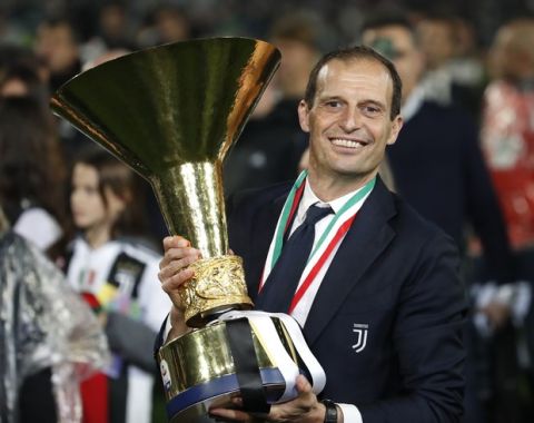 Juventus coach Massimiliano Allgeri holds the Serie A soccer title trophy, at the Allianz Stadium in Turin, Italy, Sunday, May 19, 2019. (AP Photo/Antonio Calanni)