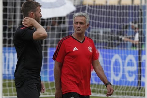 Manchester United's manager Jose Mourinho, center, talks to the captain Michael Carrick, left, during a training session at Philip II Arena in Skopje, Macedonia, Monday, Aug. 7, 2017, a day ahead of UEFA Super Cup final soccer match with Real Madrid. (AP Photo/Boris Grdanoski)