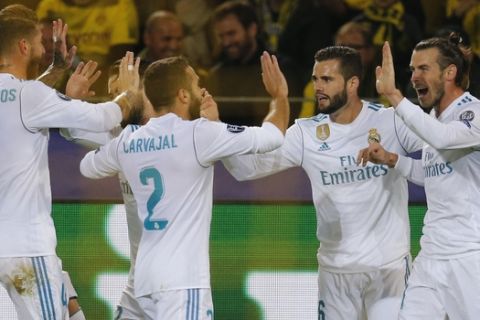 Real Madrid players celebrate with Gareth Bale, right, after he scored his side's first goal during a Champions League Group H soccer match between Borussia Dortmund and Real Madrid at the BVB stadium in Dortmund, Germany, Tuesday, Sept. 26, 2017. (AP Photo/Michael Probst)