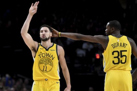 Golden State Warriors guard Klay Thompson, left, is patted on his head by forward Kevin Durant, right, after hitting a shot late in an NBA basketball game against the Portland Trail Blazers in Portland, Ore., Saturday, Dec. 29, 2018. The Warriors won 115-105. (AP Photo/Steve Dykes)