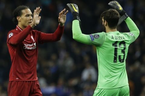 Liverpool's Virgil van Dijk, left, greets Liverpool goalkeeper Alisson Becker end of the during the Champions League quarterfinal, 2nd leg, soccer match between FC Porto and Liverpool at the Dragao stadium in Porto, Portugal, Wednesday, April 17, 2019. (AP Photo/Armando Franca)