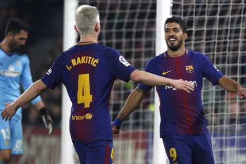 Barcelona's Suarez, right, celebrates with teammate Rakitic after scoring against Betis during the La Liga soccer match between Barcelona and Betis at the Villamarin stadium, in Seville, Spain on Sunday, Jan. 21, 2018. (AP Photo/Miguel Morenatti)