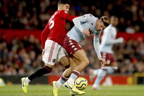 Manchester United's Andreas Pereira, left, battles for the ball with Aston Villa's Jack Grealish during the English Premier League soccer match at Old Trafford, Manchester, England, Sunday Dec. 1, 2019. (Martin Rickett/PA via AP)