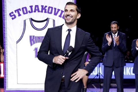 Former Sacramento Kings forward Peja Stojakovic, of Serbia, smiles after the team retired his jersey during a ceremony at the half time of an NBA basketball game against the Oklahoma City Thunder  in Sacramento, Calif., Tuesday, Dec. 16, 2014.  In the background are Stojakovic's former Kings teammates Vlade Divac, third from right, of Serbia,  Doug Christie, second from right, and Scott Pollard, right, The Thunder won 104-92. (AP Photo/Rich Pedroncelli)
