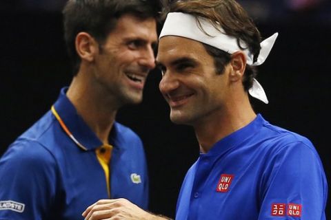 Team Europe's Roger Federer, right, and Novak Djokovic share a laugh during a men's doubles tennis match against Team World's Jack Sock and Kevin Andersonat the Laver Cup, Friday, Sept. 21, 2018, in Chicago. (AP Photo/Jim Young)