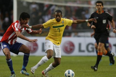 Brazilian forward Robinho (C) is marked by Paraguayan midfielder Victor Caceres during a 2011 Copa America quarter-final football match held at the Ciudad de La Plata stadium in La Plata, 59 Km south of Buenos Aires, on July 17, 2011.   AFP PHOTO / Maxi Failla (Photo credit should read Maxi Failla/AFP/Getty Images)