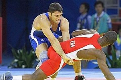 epa01445089 Andrea Minguzzi of Italy (L) competes with Melonin Noumonvi of France (R) during the Men's Greco-Roman 84kg wrestling match at the China Agricultural University Gymnasium for the Beijing 2008 Olympic Games, in Beijing, China, 14 August 2008. Minguzzi won the match.  EPA/RUNGROJ YONGRIT