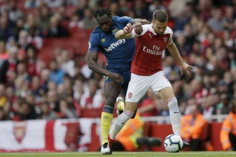 West Ham's Michail Antonio left, vies for the ball with Arsenal's Aaron Ramsey during the English Premier League soccer match between Arsenal and West Ham United at the Emirates Stadium in London, Saturday Aug. 25, 2018. (AP Photo/Tim Ireland)
