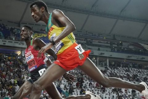Conseslus Kipruto, left, of Kenya, wins ahead of Lamecha Girma, right, of Ethiopia, in the men's 3000 meter steeplechase final at the World Athletics Championships in Doha, Qatar, Friday, Oct. 4, 2019. (AP Photo/David J. Phillip)