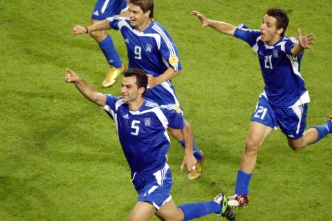 epa000224673 Greek player Traianos Dellas celebrates with team-mates Angelos Charisteas (rear left) and Konstantinos Katsouranis (right) after scoring the Silver Goal during the EURO 2004 semi final match between Greece and the Czech Republic at the Dragao stadium in Porto on Thursday, 01 July 2004.  EPA/ANTONIO SIMOES NO MOBILE PHONE APPLICATIONS
