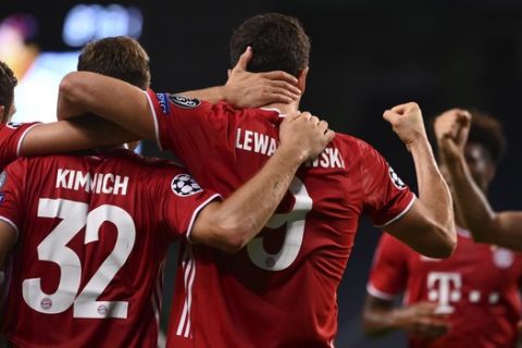 Bayern's Robert Lewandowski celebrates with teammates after scoring his side's third goal during the Champions League semifinal soccer match between Lyon and Bayern at the Jose Alvalade stadium in Lisbon, Portugal, Wednesday, Aug. 19, 2020. (Franck Fife/Pool via AP)