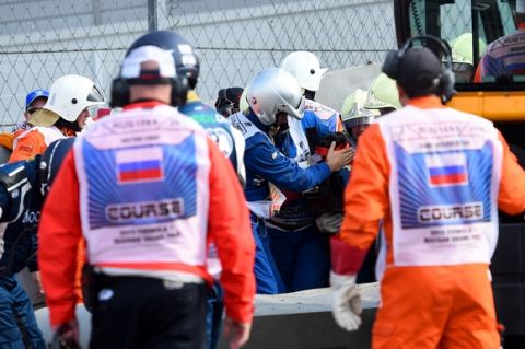 SOCHI, RUSSIA - OCTOBER 10:  Doctors assist Carlos Sainz of Spain and Scuderia Toro Rosso after he crashed during final practice for the Formula One Grand Prix of Russia at Sochi Autodrom on October 10, 2015 in Sochi, Russia.  (Photo by Lars Baron/Getty Images)