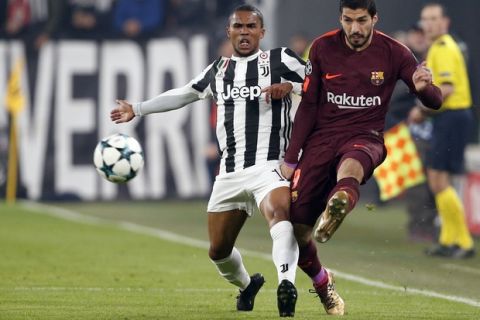 Barcelona's Luis Suarez kicks the ball past Juventus' Douglas Costa during the Champions League group D soccer match between Juventus and Barcelona, at the Allianz Stadium in Turin, Italy, Wednesday, Nov. 22, 2017. (AP Photo/Antonio Calanni)