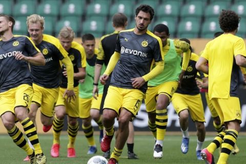 Dortmund's Lukasz Piszczek, left, and Mats Hummels, center, exercise during warmup before the German Bundesliga soccer match between VfL Wolfsburg and Borussia Dortmund in Wolfsburg, Germany, Saturday, May 23, 2020. The German Bundesliga is the world's first major soccer league to resume after a two-month suspension because of the coronavirus pandemic. (AP Photo/Michael Sohn, Pool)