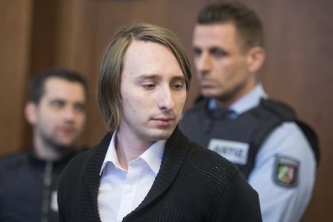 Sergej W., no family name given due to German privacy laws, who is charged with detonating three bombs targeting the Borussia Dortmund soccer team bus last April, arrives for the second day of his trial at a German state court in Dortmund, Germany, Monday, Jan. 8, 2018. (Bernd Thissen/Pool photo via AP)