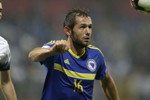 FILE - A Zenica Tuesday, Sept. 6, 2016 file photo of Bosnia's Senad Lulic, right, controlling the ball as Estonia's Artur Pikk looks on during their World Cup Group H qualifying match at the Bilino Pole Stadium in Zenica Bosnia . Lazio midfielder Senad Lulic has been banned for 20 days and fined 10,000 euros (around $10,500) Thursday Dec. 22, 2016, for a racist insult toward Roma defender Antonio Rudiger following the Rome derby. (AP Photo/Amel Emric, File)