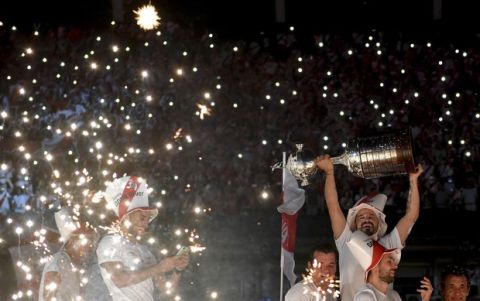Rodrigo Mora of Argentina's River Plate holds the trophy as he celebrates with teammates at their stadium in Buenos Aires, Argentina, Sunday Dec. 23, 2018. River Plate won the Copa Libertadores final against Argentina's Boca Juniors. (AP Photo/Pablo Stefanec)