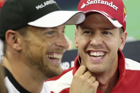 Ferrari driver Sebastian Vettel, right, of Germany smiles as he looks at McLaren driver Jenson Button of Britain at the official press conference ahead of the Japanese Formula One Grand Prix at the Suzuka Circuit in Suzuka, central Japan, Thursday, Sept. 24, 2015. (AP Photo/Rob Griffith)
