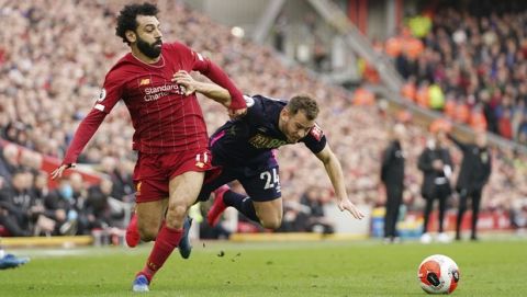 Liverpool's Mohamed Salah, left, challenges for the ball with Bournemouth's Ryan Fraser during the English Premier League soccer match between Liverpool and Bournemouth at Anfield stadium in Liverpool, England, Saturday, March 7, 2020. (AP Photo/Jon Super)