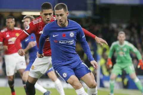 Chelsea's Eden Hazard and Manchester United's Chris Smalling, rear, challenge for the ball during the English Premier League soccer match between Chelsea and Manchester United at Stamford Bridge stadium in London, Sunday, Nov. 5, 2017.(AP Photo/Frank Augstein)