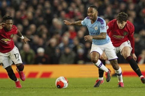 Manchester City's Raheem Sterling, center, and Manchester United's Victor Lindelof, right, compete for the ball during the English Premier League soccer match between Manchester United and Manchester City at Old Trafford in Manchester, England, Sunday, March 8, 2020. (AP Photo/Dave Thompson)