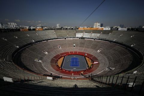 Workers add the finishing touches at the Plaza de Toros Mexico bullring that has been converted into a tennis court to host an upcoming exhibition tennis match between Swiss great Roger Federer and German rival Alexander Zverev, in Mexico City, Friday, Nov. 22, 2019. At the end of Saturday night's event, workers will dismantle the court in order to welcome its regular visitors on Sunday to watch the fourth bullfights of the season. (AP Photo/Rebecca Blackwell)
