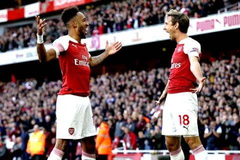 Arsenal's Pierre-Emerick Aubameyang, left celebrates with Arsenal's Nacho Monreal after scoring his side's 2nd goal during an English Premier League soccer match between Arsenal and Everton at the Emirates Stadium in London, Sunday Sept. 23, 2018. (AP Photo/Tim Ireland)