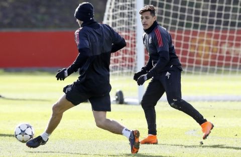 Manchester United's Alexis Sanchez, right, attends a training session ahead of Wednesday's Champions League, round of 16 first-leg soccer match against Sevilla, at the AON Training Complex, Carrington, England, Tuesday, Feb. 20, 2018.  (Martin Rickett/PA via AP)