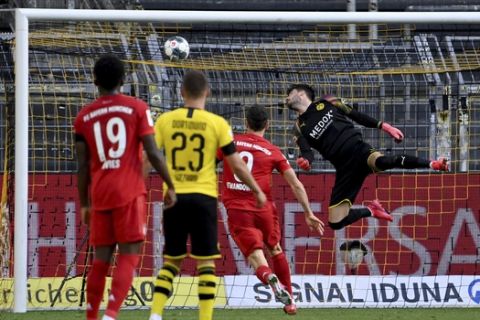 Dortmund's goalkeeper Roman Buerki, right, fails to safe a shot by Munich's Joshua Kimmich during the German Bundesliga soccer match between Borussia Dortmund and FC Bayern Munich in Dortmund, Germany, Tuesday, May 26, 2020. The German Bundesliga is the world's first major soccer league to resume after a two-month suspension because of the coronavirus pandemic. (Federico Gambarini/DPA via AP, Pool)