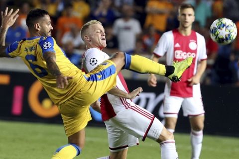 Ajax's Donny van de Beek, right, challenges for the ball with APOEL's Savvas Gentsoglou during the Champions League qualifying play-off first leg soccer match between APOEL Nicosia and AFC Ajax at GSP stadium in Nicosia, Cyprus, Tuesday, Aug. 20, 2019.(AP Photo/Philippos Christou)