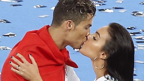 Real Madrid's Cristiano Ronaldo, left, is kissed by his girlfriend Georgina Rodriguez after winning the Champions League Final soccer match between Real Madrid and Liverpool at the Olimpiyskiy Stadium in Kiev, Ukraine, Saturday, May 26, 2018. Madrid defeated Liverpool by 3-1. (AP Photo/Darko Vojinovic)