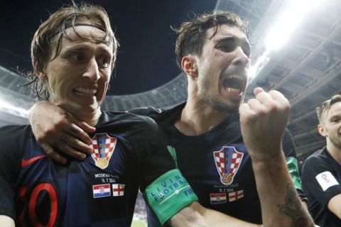 Croatia's Luka Modric, left, Sime Vrsaljko and Ivan Rakitic, right, celebrate after Croatia's Mario Mandzukic scored his side's second goal during the semifinal match between Croatia and England at the 2018 soccer World Cup in the Luzhniki Stadium in Moscow, Russia, Wednesday, July 11, 2018. (AP Photo/Frank Augstein)