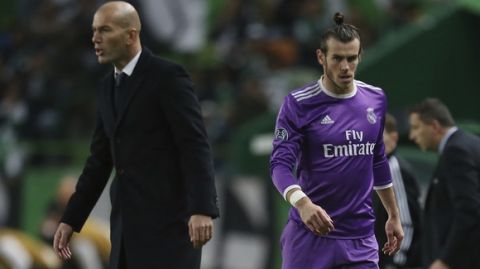 Real Madrid's Gareth Bale, right, leaves the pitch as head coach Zinedine Zidane gives directions to his payers during the Champions League Group F soccer match between Sporting CP and Real Madrid at the Alvalade stadium in Lisbon, Tuesday, Nov. 22, 2016. (AP Photo/Armando Franca)