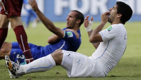 FILE - In this June 24, 2014 file photo, Uruguay's Luis Suarez holds his teeth after biting Italy's Giorgio Chiellini's shoulder during the group D World Cup soccer match between Italy and Uruguay in Natal, Brazil.  (AP Photo/Ricardo Mazalan, File)
