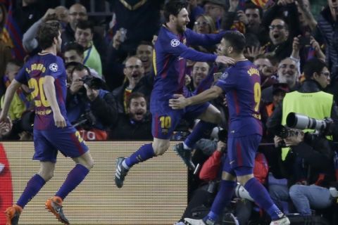 Barcelona's Lionel Messi, center, jumps into the arms of Barcelona's Luis Suarez, right, after scoring his side's first goal during the Champions League round of sixteen second leg soccer match between FC Barcelona and Chelsea at the Camp Nou stadium in Barcelona, Spain, Wednesday, March 14, 2018. Left is Barcelona's Sergi Roberto. (AP Photo/Emilio Morenatti)