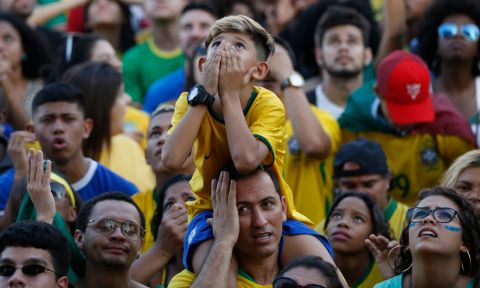 Worried Brazil soccer fans watch a live telecast of the Brazil vs. Belgium World Cup quarter finals soccer match, in Rio de Janeiro, Brazil, Friday, July 6, 2018. (AP Photo/Silvia Izquierdo)