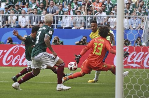 Brazil's Neymar, background right, tries to score past Mexico goalkeeper Guillermo Ochoa, right, during the round of 16 match between Brazil and Mexico at the 2018 soccer World Cup in the Samara Arena, in Samara, Russia, Monday, July 2, 2018. (AP Photo/Thanassis Stavrakis)
