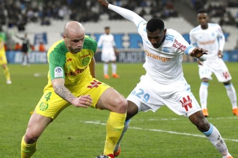 Nantes' Nicolas Pallois, left, challenges for the ball with Marseille's Andre-Franck Zambo Anguissa, during the League One soccer match between Marseille and Nantes, at the Velodrome stadium, in Marseille, southern France, Sunday March 4, 2018. (AP Photo/Claude Paris)