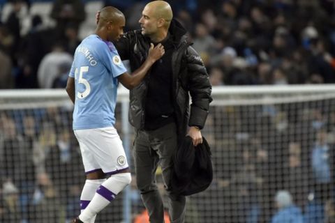 Manchester City's head coach Pep Guardiola, right, speaks with Manchester City's Fernandinho at the end of the English Premier League soccer match between Manchester City and Manchester United at Etihad stadium in Manchester, England, Saturday, Dec. 7, 2019. (AP Photo/Rui Vieira)